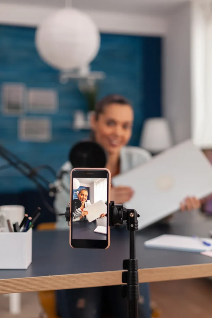 closeup-smartphone-recording-product-review-mobile-phone-filming-woman-presenter-doing-vlog-testing-laptop-computer-social-media-influencer-doing-gadget-recommendation-front-camera